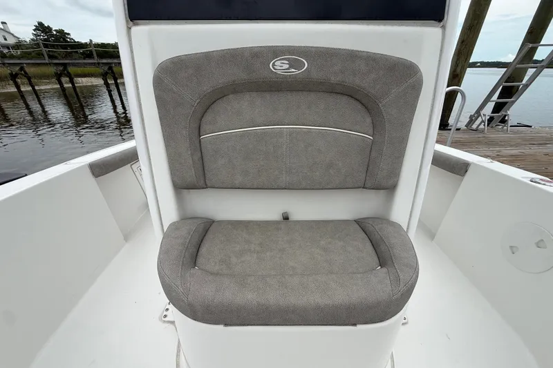 Slide: The Image of 2025 Sea Hunt BX25FS boat seat with gray upholstery, dockside view. - 26
