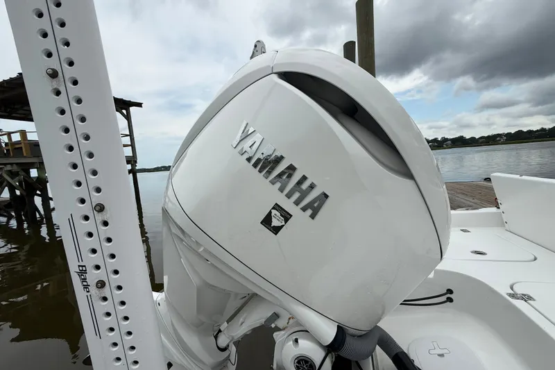 Slide: The Image of 2025 Sea Hunt BX25FS boat with Yamaha outboard motor on a calm waterway. - 6