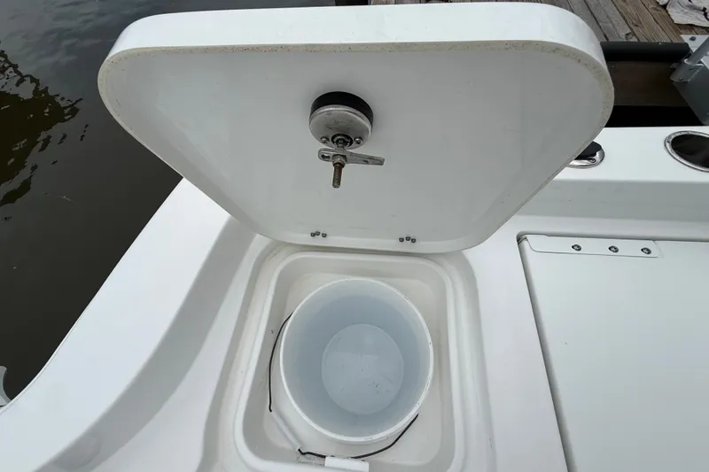 Slide: The Image of Open storage compartment on 2025 Sea Hunt BX25FS boat with bucket inside. - 30