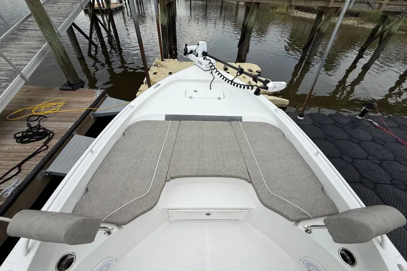 Slide: The Image of 2025 Sea Hunt BX25FS boat bow with cushioned seating at dock. - 22