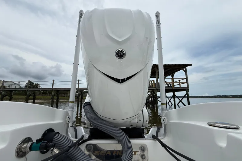 Slide: The Image of 2025 Sea Hunt BX25FS boat engine with dock in background, overcast sky. - 5