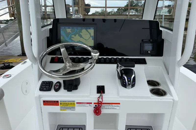 Slide: The Image of 2025 Sea Hunt BX25FS boat dashboard with steering wheel, navigation screen, and controls. - 8