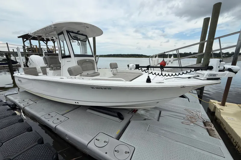 Slide: The Image of 2025 Sea Hunt BX25FS boat docked on a floating platform by the water. - 1