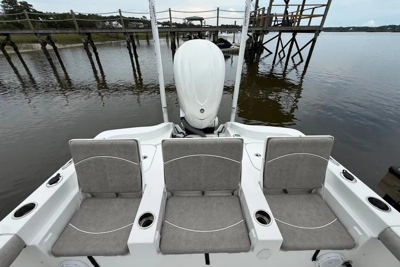Slide: The Image of 2025 Sea Hunt BX25FS boat with three cushioned seats, docked by wooden pier. - 28