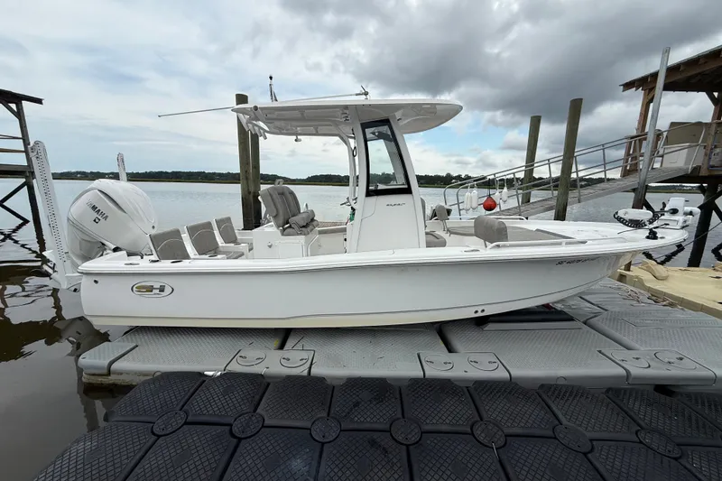 The Image of 2025 Sea Hunt BX25FS boat docked on a floating platform under cloudy skies. - 0