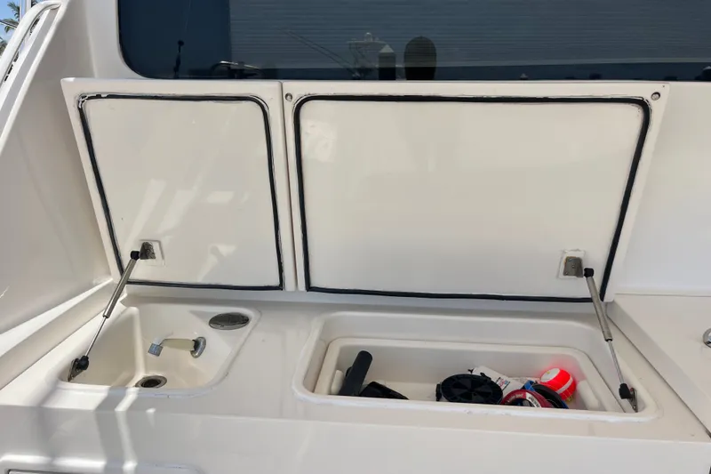 Slide: The Image of Open storage compartments on a 2004 Ocean Yacht 52 Super Sport, featuring a sink and equipment. - 22