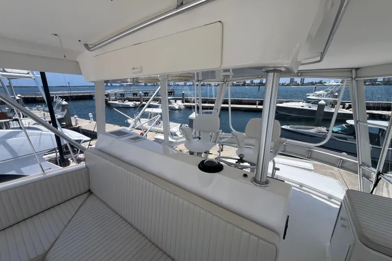 Slide: The Image of 2004 Ocean Yacht 52 Super Sport interior with marina view, featuring white seating and helm chairs. - 31