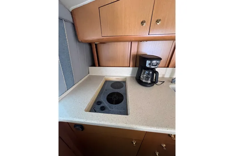 Slide: The Image of Compact kitchen area in a 2004 Ocean Yacht 52 Super Sport with stove and coffee maker. - 5