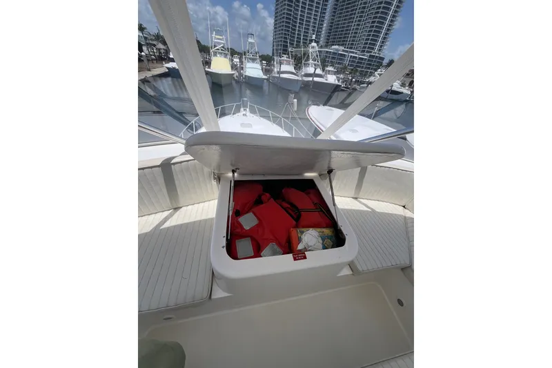 Slide: The Image of Open storage compartment on 2004 Ocean Yacht 52 Super Sport, containing life jackets and maps. - 30