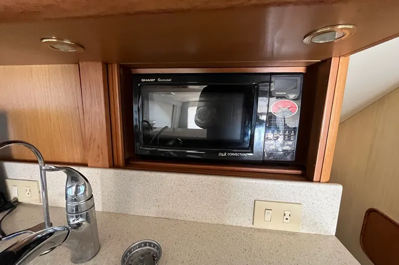 Slide: The Image of Microwave in 2004 Ocean Yacht 52 Super Sport kitchen with wooden cabinetry and countertop. - 6
