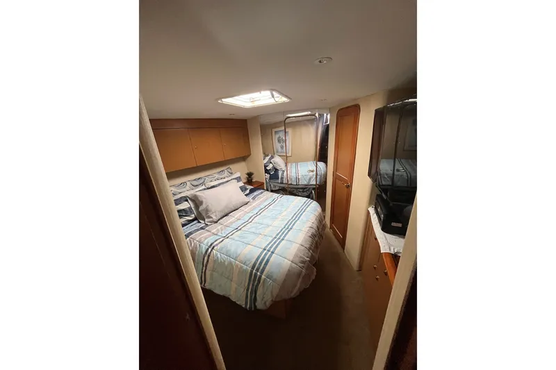 Slide: The Image of Cozy bedroom interior of 2004 Ocean Yacht 52 Super Sport with striped bedding. - 15