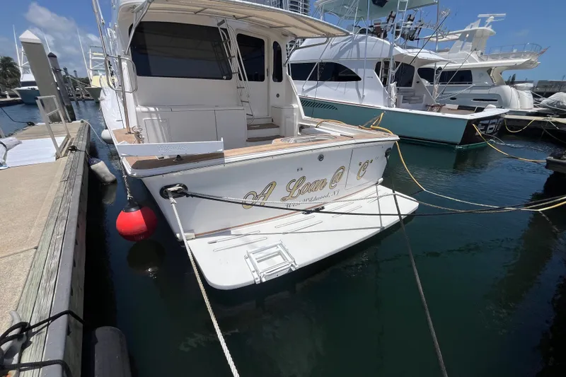 Slide: The Image of 2004 Ocean Yacht 52 Super Sport docked at marina, rear view with name visible. - 20