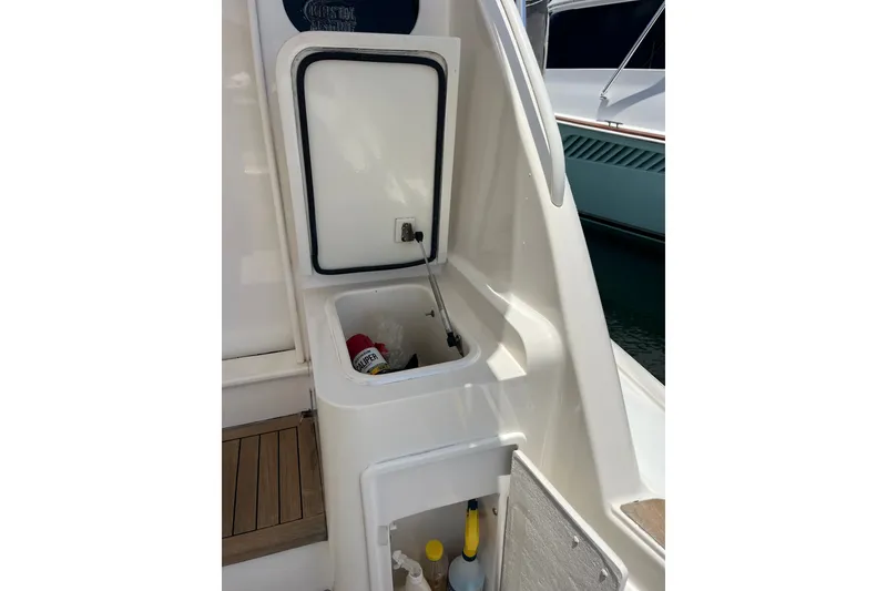 Slide: The Image of Open storage compartment on 2004 Ocean Yacht 52 Super Sport, containing cleaning supplies. - 24