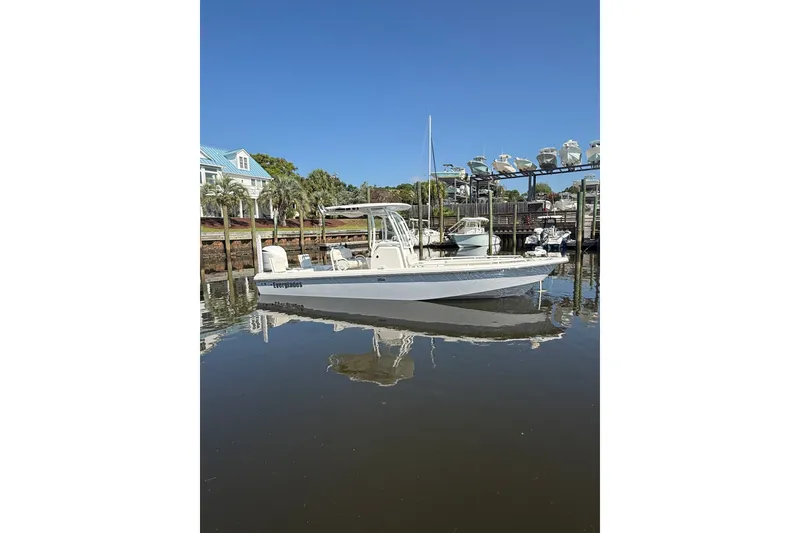The Image of 2020 Everglades 243 Center Console boat docked in a marina under clear blue skies. - 1