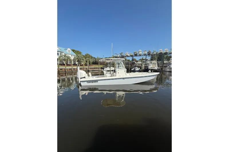 Slide: The Image of 2020 Everglades 243 Center Console boat docked in a marina under clear blue skies. - 12