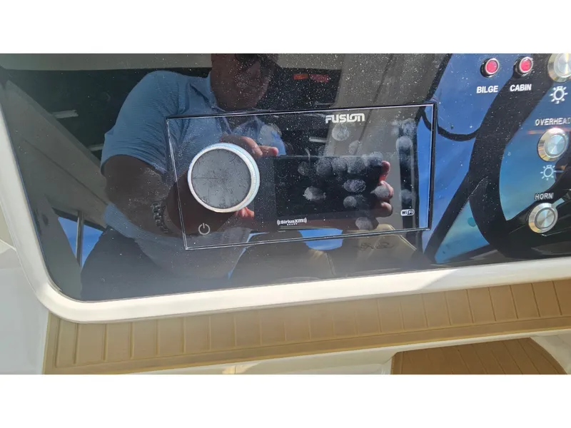 Slide: The Image of Close-up of a boat control panel with Fusion audio system and various switches. - 31