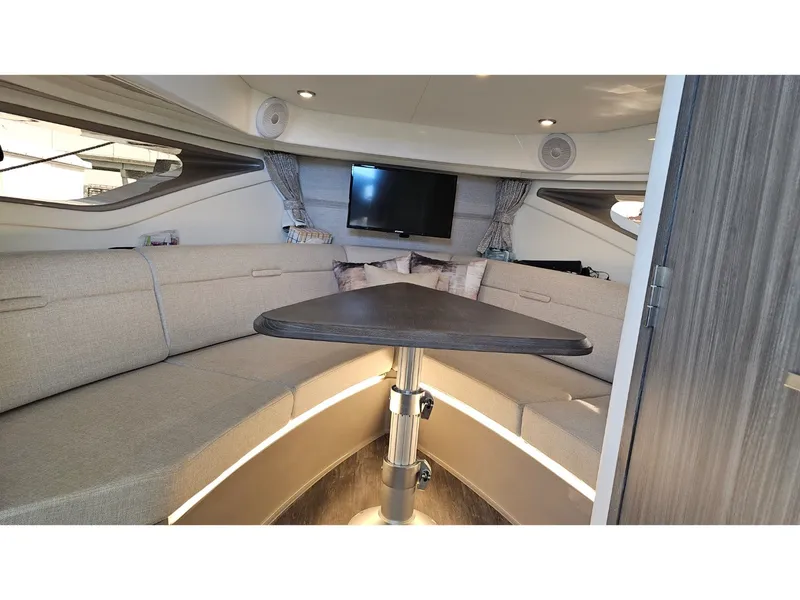 Slide: The Image of Interior of the 2026 Sea Ray Sundancer 320 Coupe Outboard with cozy seating and table. - 15