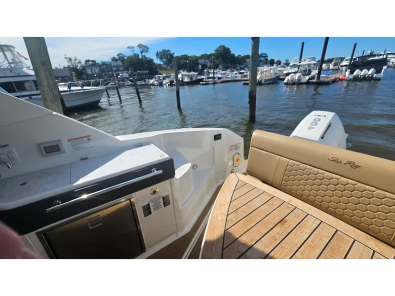 Slide: The Image of The image shows the stern of a Sea Ray Sundancer 320 Coupe Outboard with a sleek wood deck. - 26