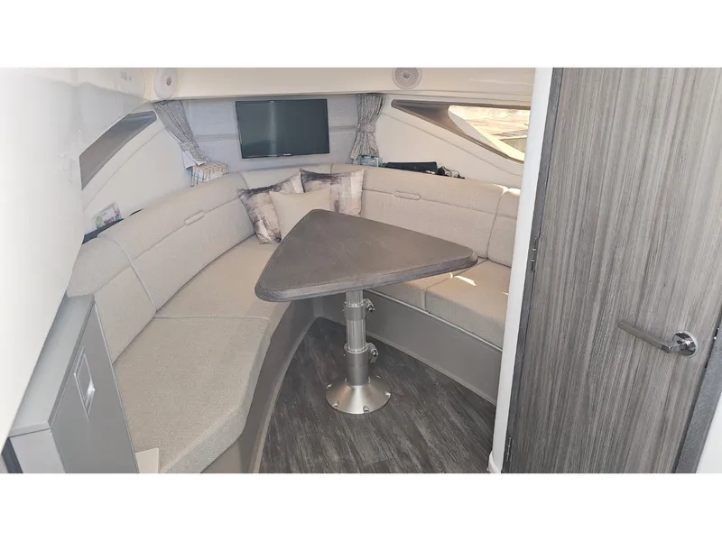 Slide: The Image of Interior of the 2026 Sea Ray Sundancer 320 Coupe Outboard with elegant seating area and table. - 8