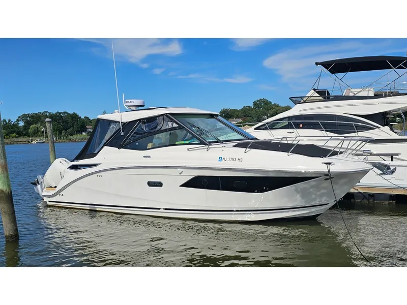 Slide: The Image of 2026 Sea Ray Sundancer 320 Coupe Outboard at dock, sleek design, modern hardtop. - 1