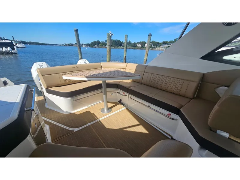 Slide: The Image of The image shows the cockpit of a Sea Ray Sundancer 320 Coupe Outboard with beige seating and a table. - 38
