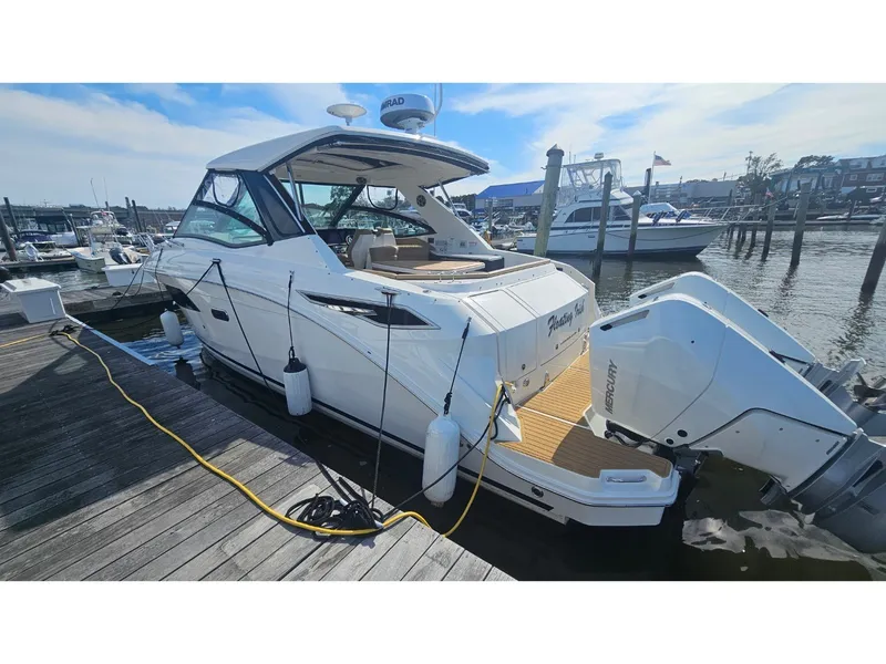 Slide: The Image of The 2026 Sea Ray Sundancer 320 Coupe Outboard is docked. It features a sleek design with outboard engines. - 42