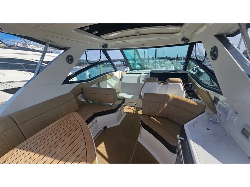 Slide: The Image of Interior of the 2026 Sea Ray Sundancer 320 Coupe Outboard with sleek seating and wooden table. - 28