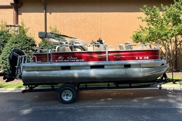 The Image of 2021 Sun Tracker Bass Buggy 18 DLX pontoon boat on trailer, parked outdoors. - 0