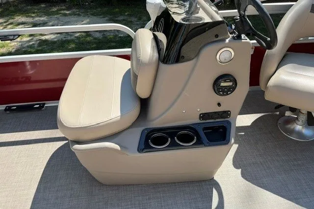 Slide: The Image of 2021 Sun Tracker Bass Buggy 18 DLX boat console with beige seating and cup holders. - 13