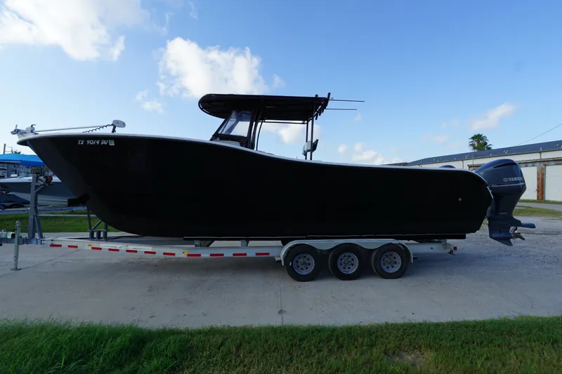 The Image of 2014 AmeraCat 31 boat on trailer, black hull, dual Yamaha engines, outdoor setting. - 0