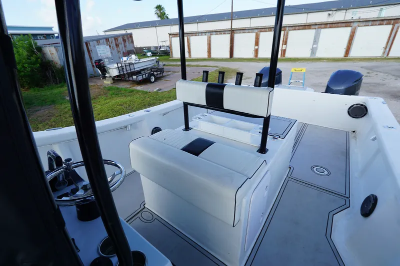 Slide: The Image of 2014 AmeraCat 31 boat interior with seating and steering wheel, parked outdoors. - 9