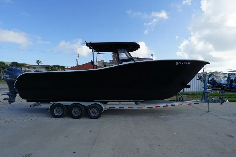 Slide: The Image of 2014 AmeraCat 31 boat on trailer under blue sky. - 1