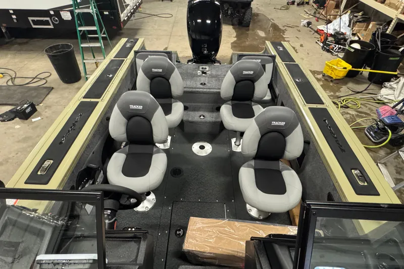 Slide: The Image of 2027 Tracker Targa V-18 Combo boat interior with four seats in a workshop. - 19
