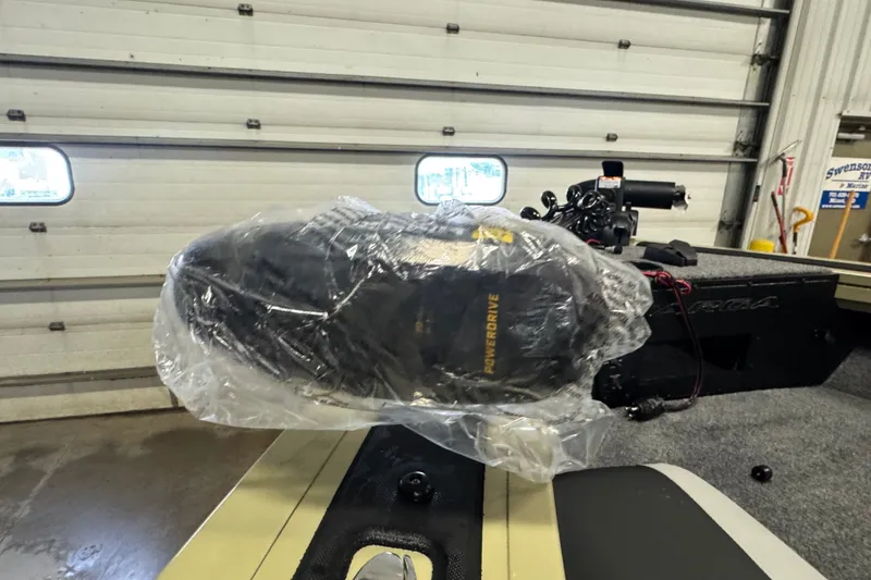 Slide: The Image of 2027 Tracker Targa V-18 Combo boat with covered motor in garage. - 18