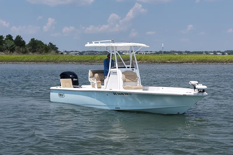 The Image of 2018 Sea Hunt BX22BR boat on calm water, featuring a sleek design and powerful engine. - 0