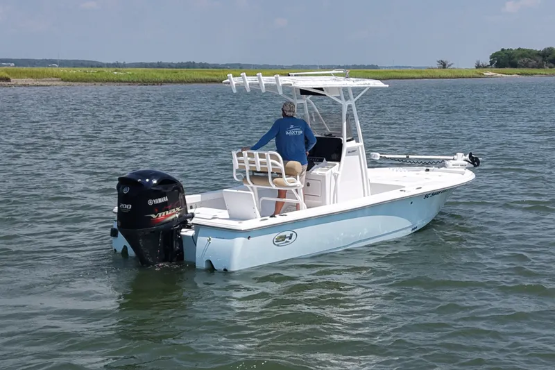 Slide: The Image of 2018 Sea Hunt BX22BR boat on water with Yamaha engine, person steering. - 3
