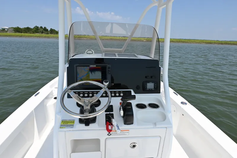 Slide: The Image of 2018 Sea Hunt BX22BR boat console with steering wheel and navigation system on open water. - 11