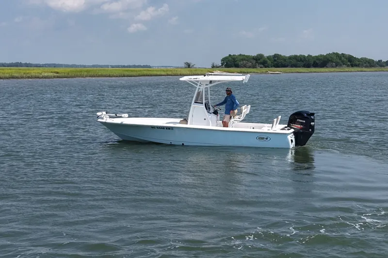 Slide: The Image of 2018 Sea Hunt BX22BR boat on calm water with a person onboard. - 2