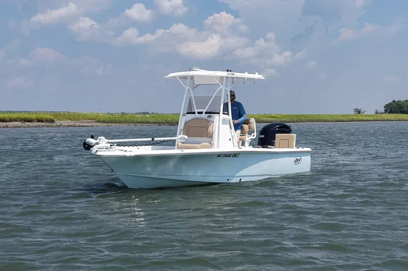 Slide: The Image of 2018 Sea Hunt BX22BR boat on calm water under a partly cloudy sky. - 1
