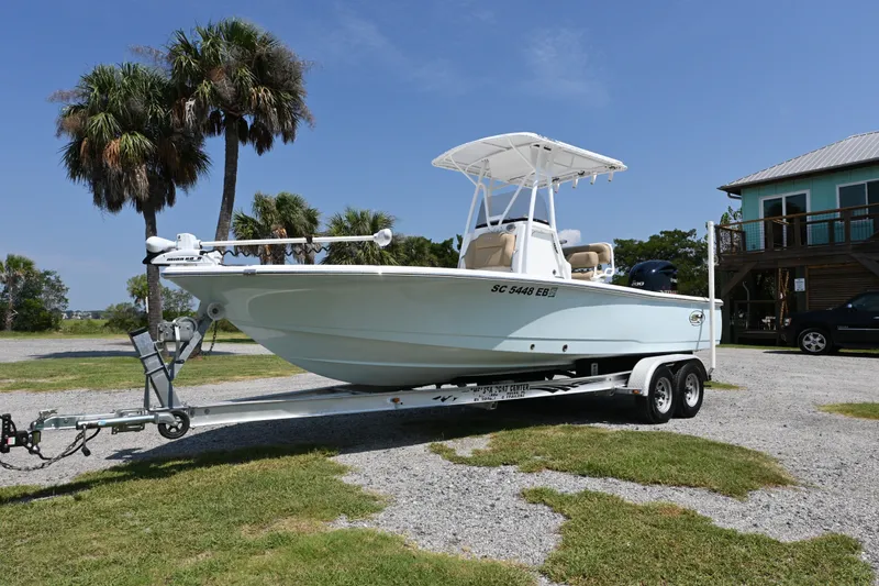 Slide: The Image of 2018 Sea Hunt BX22BR boat on trailer, parked outdoors near palm trees and a house. - 15