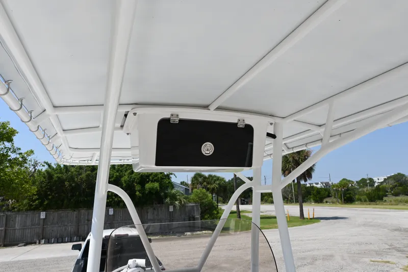 Slide: The Image of 2018 Sea Hunt BX22BR boat T-top with storage compartment, parked outdoors. - 8
