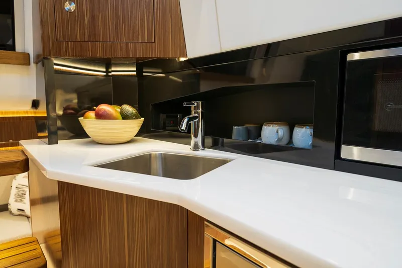 Slide: The Image of Manufacturer Provided Image: Modern kitchen area in 2022 Sea Ray Sundancer 370 OB yacht with sink and fruit bowl. - 15