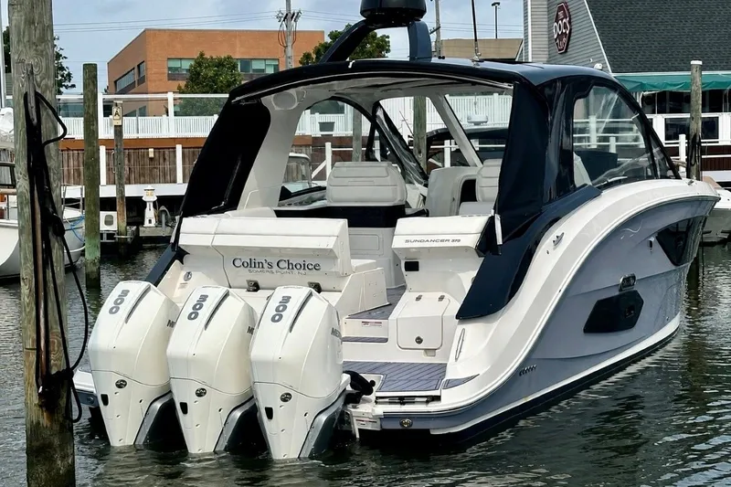 Slide: The Image of 2022 Sea Ray Sundancer 370 Outboard docked, featuring triple Mercury engines. - 2