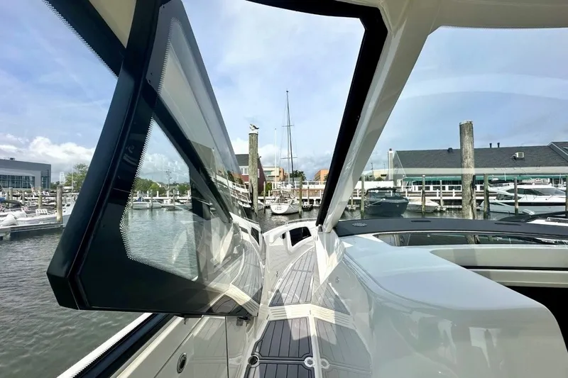Slide: The Image of 2022 Sea Ray Sundancer 370 Outboard at marina, showcasing sleek design and open window. - 7