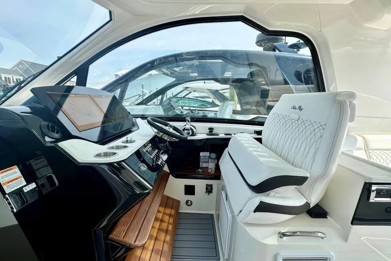 Slide: The Image of Interior of 2022 Sea Ray Sundancer 370 Outboard, featuring modern helm and luxurious seating. - 12