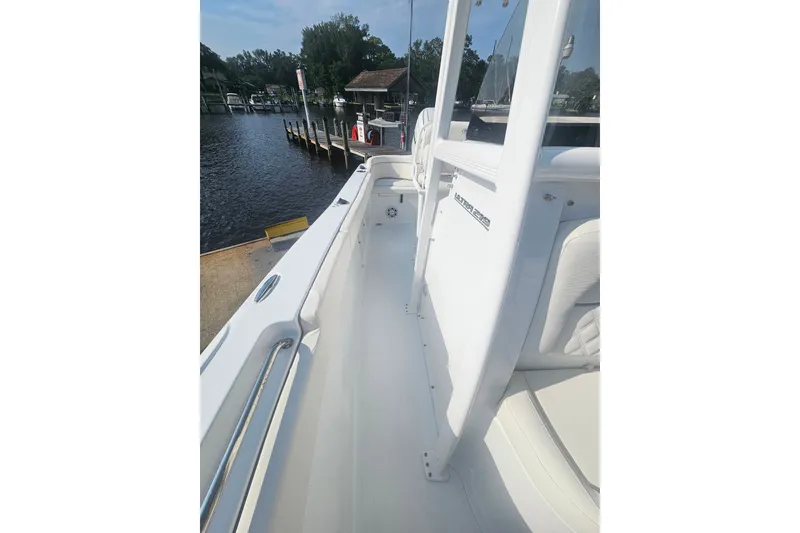 Slide: The Image of 2027 Sea Hunt Ultra 219 boat interior, docked by a serene waterfront. - 30