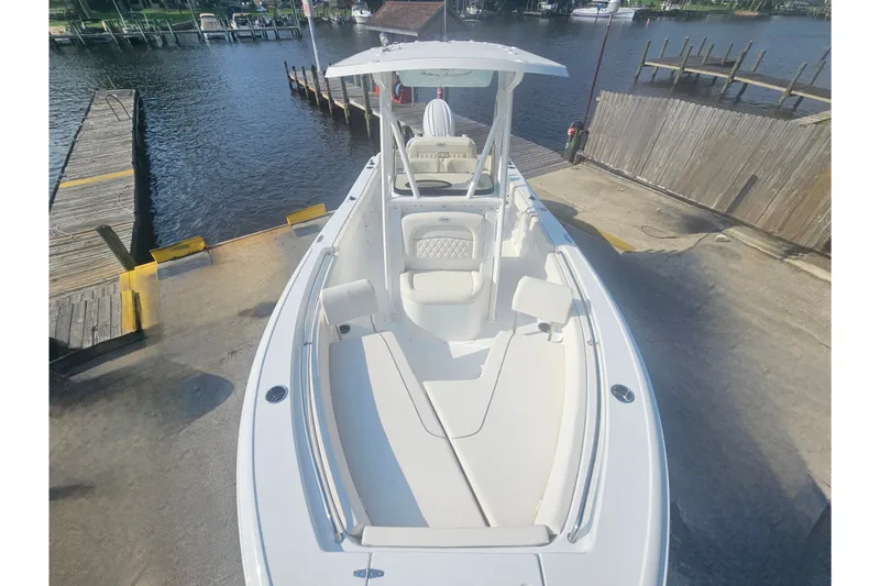 Slide: The Image of 2027 Sea Hunt Ultra 219 boat docked at a marina, showcasing sleek design and spacious seating. - 25