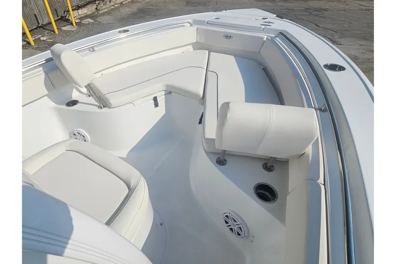 Slide: The Image of 2027 Sea Hunt Ultra 219 boat interior with white cushioned seating and cup holders. - 24