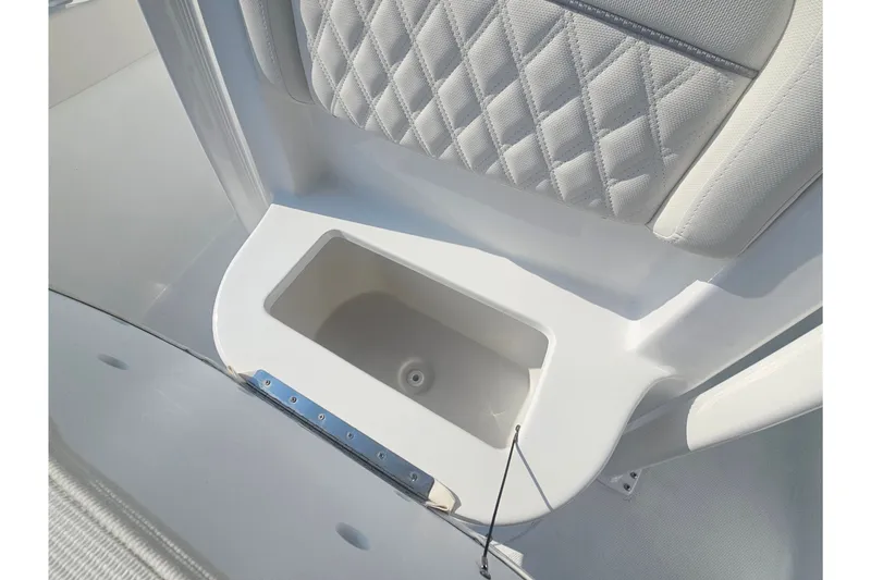 Slide: The Image of 2027 Sea Hunt Ultra 219 boat interior with cushioned seating and storage compartment. - 27