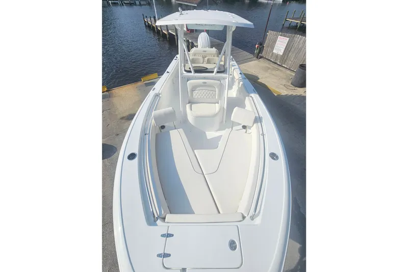 Slide: The Image of 2027 Sea Hunt Ultra 219 boat docked, showcasing sleek design and spacious seating. - 26